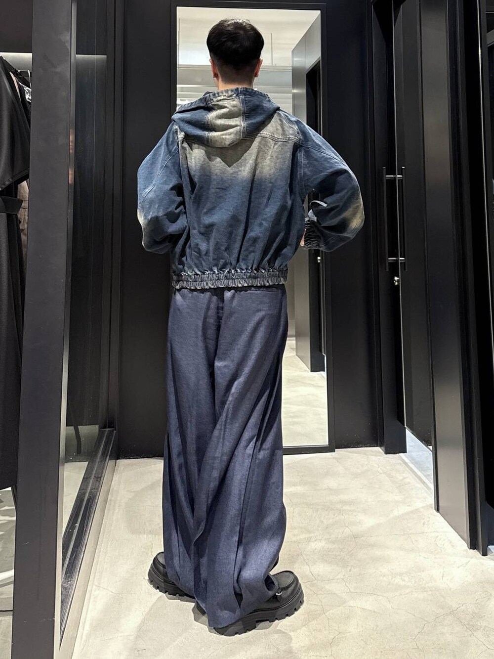 ブルー系のスラックス、ブラック系のTシャツ/カットソー、ブラック系のドレスシューズを着用したメンズの秋コーディネートの3枚目の写真