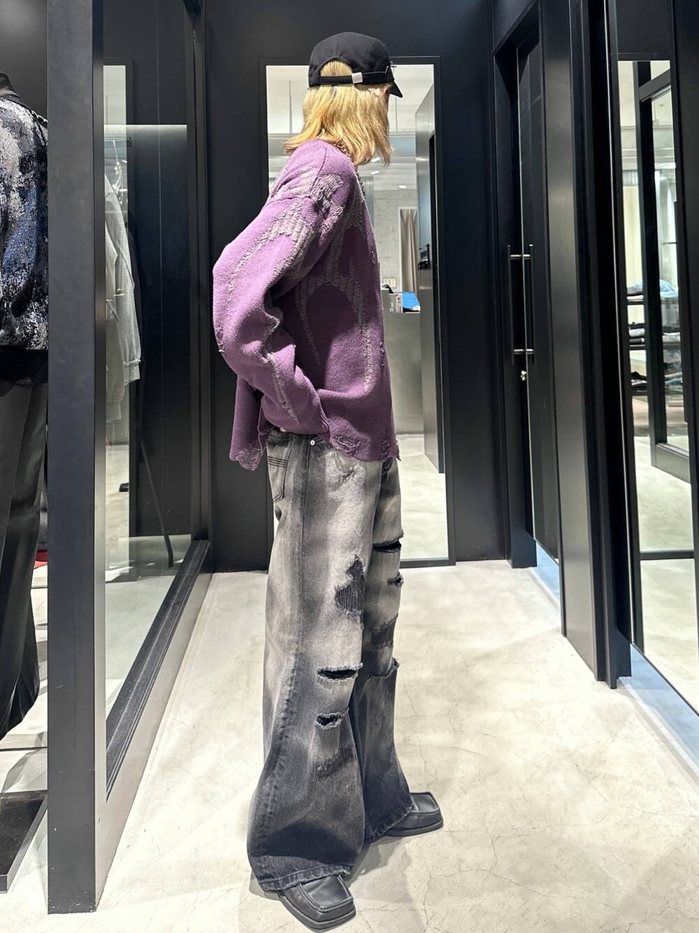 ブラック系のデニムパンツ、パープル系のニット/セーター、ブラック系のキャップを着用したメンズの秋コーディネートの2枚目の写真