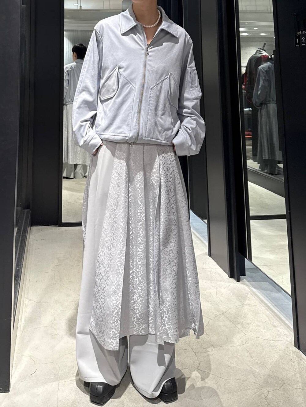 ブルー系のブルゾン、ブラック系のブーツ、グレー系のその他パンツを着用したメンズの冬コーディネートの4枚目の写真