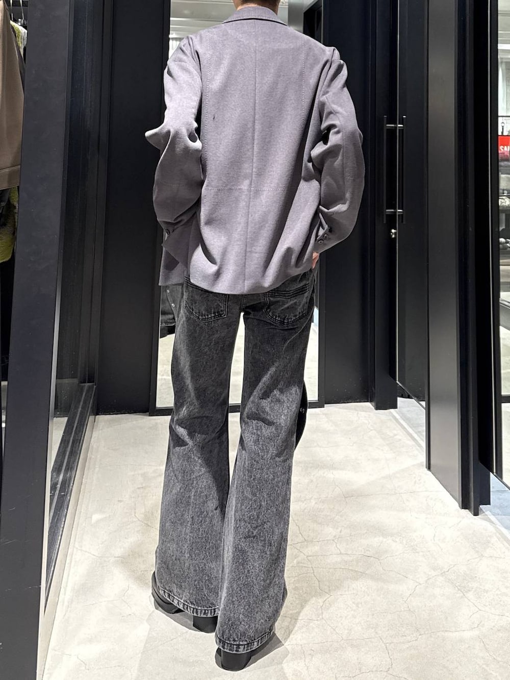 ブラック系のブーツ、グレー系のテーラードジャケット、ブラック系のデニムパンツを着用したメンズの冬コーディネートの3枚目の写真