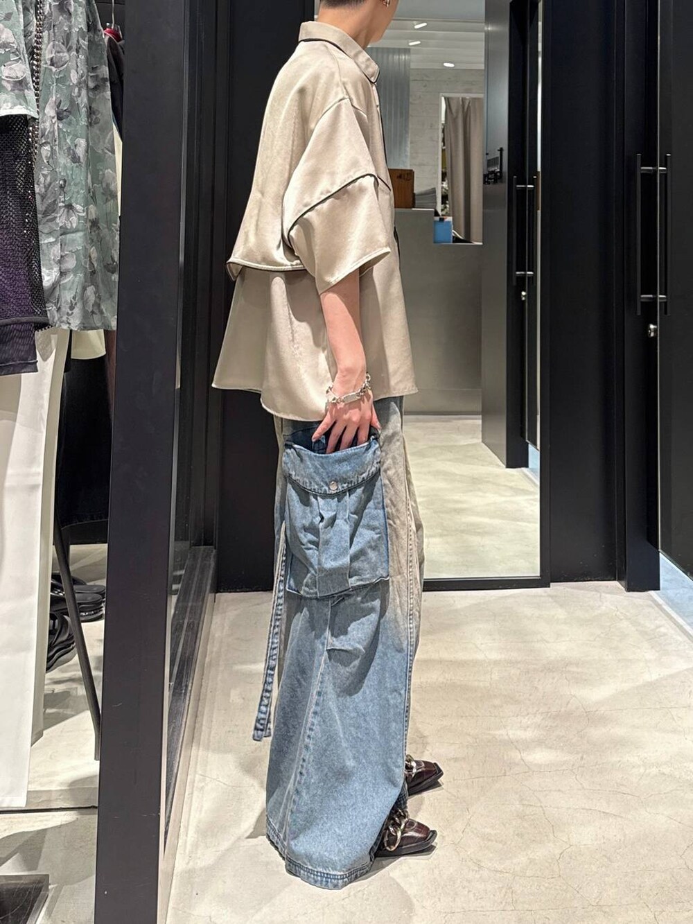 ブルー系のカーゴパンツ、ブラック系のタンクトップ、シルバー系のネックレスを着用したメンズの春コーディネートの2枚目の写真