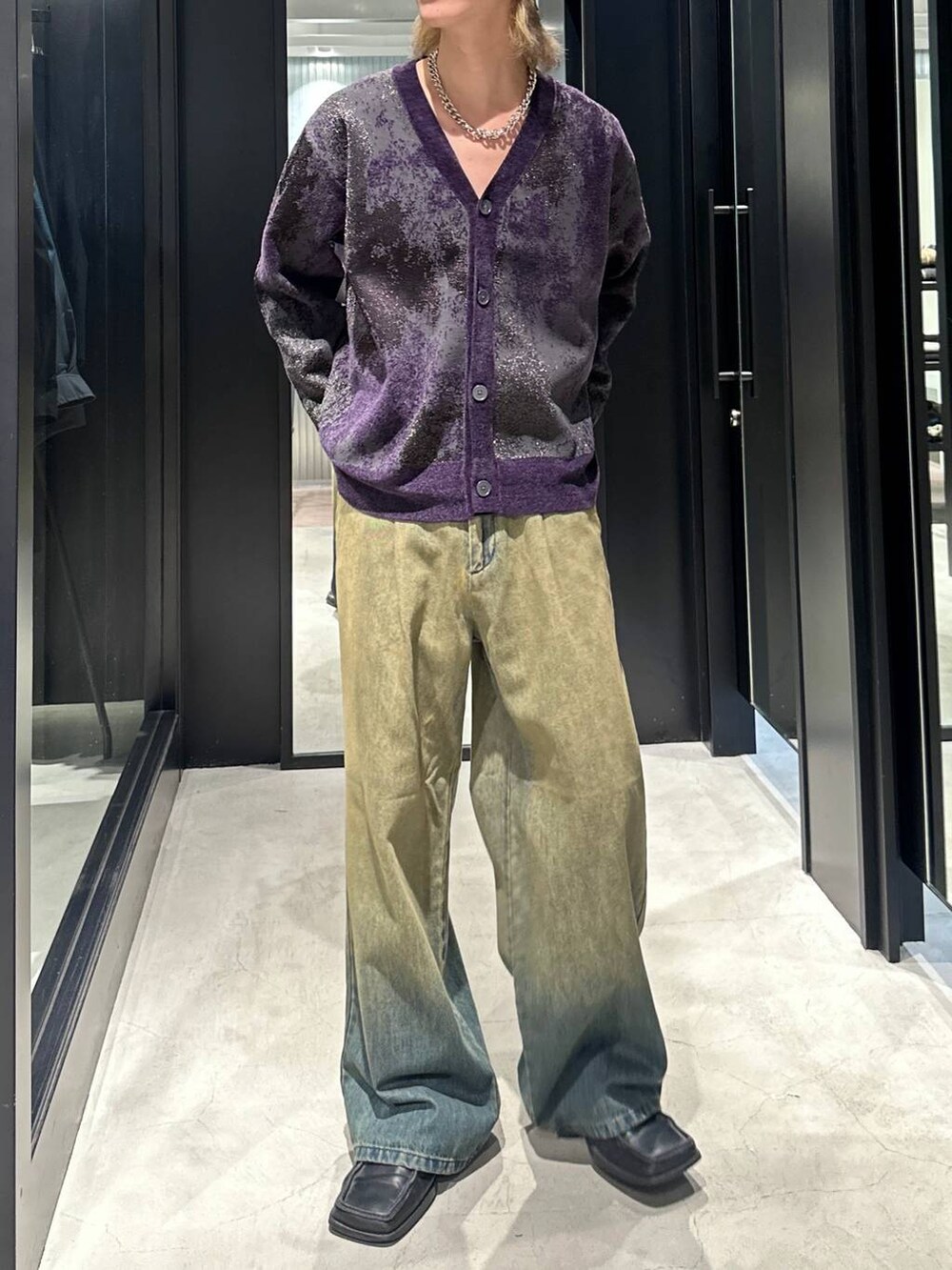 グリーン系のデニムパンツ、パープル系のカーディガン/ボレロ、シルバー系のネックレスを着用したメンズの秋コーディネートの2枚目の写真