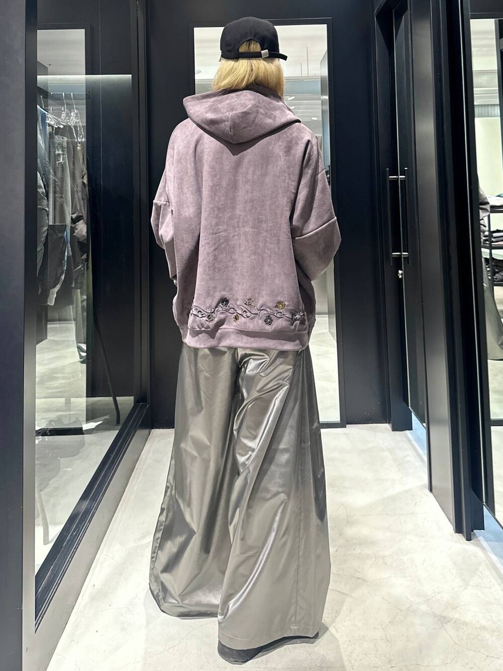 ブラウン系のパーカー、シルバー系のスラックス、ブラック系のキャップを着用したメンズの秋コーディネートの4枚目の写真