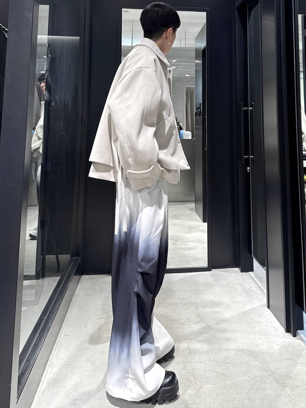 ホワイト系のブルゾン、ブラック系のその他パンツ、ホワイト系のネックレスを着用したメンズの冬コーディネートの2枚目の写真