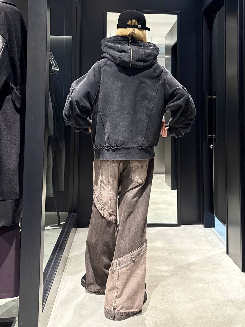 ブラウン系のデニムパンツ、ブラック系のパーカー、ブラック系のキャップを着用したメンズの秋コーディネートの3枚目の写真