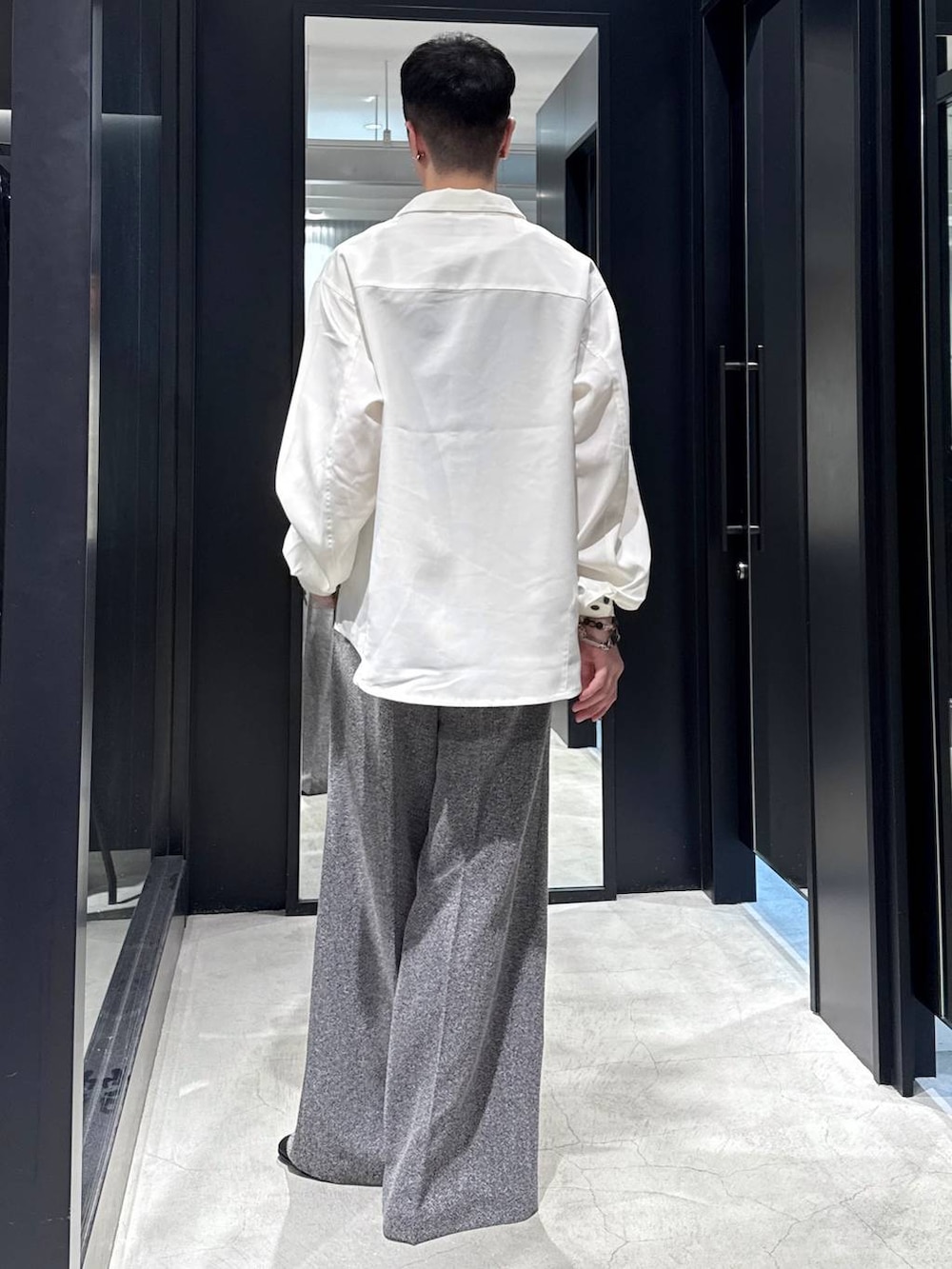 ブラック系のタンクトップ、ブラック系のバレエシューズ、ブラック系のスラックスを着用したメンズの夏コーディネートの2枚目の写真