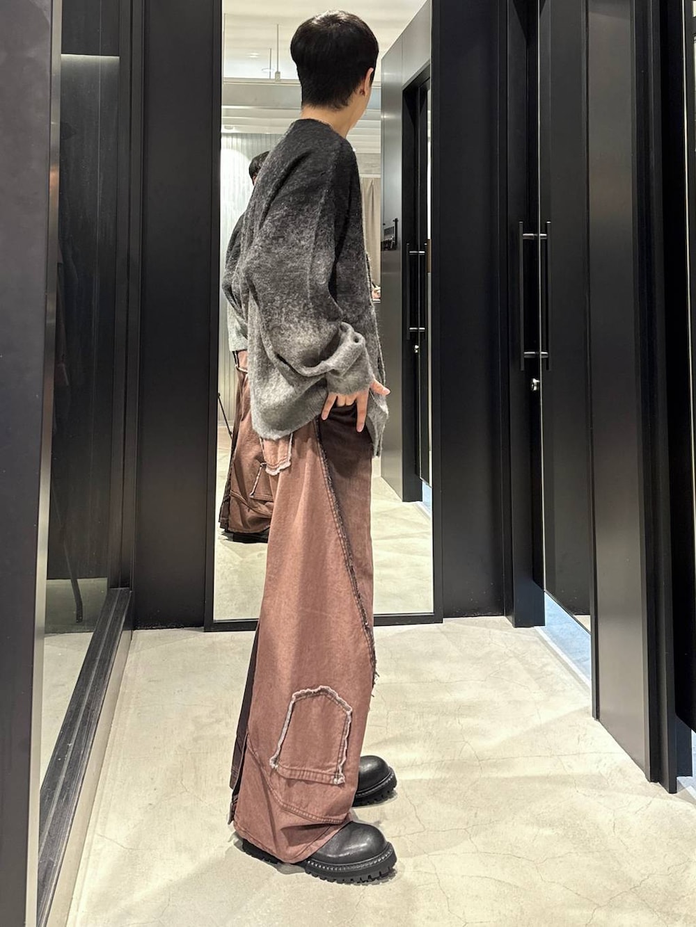 ホワイト系のTシャツ/カットソー、ブラック系のカーディガン/ボレロ、レッド系のデニムパンツを着用したメンズの秋コーディネートの2枚目の写真