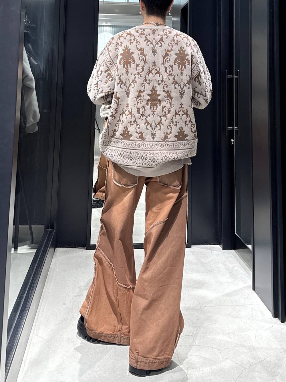 ブラック系のカーディガン/ボレロ、オレンジ系のデニムパンツ、シルバー系のネックレスを着用したメンズの冬コーディネートの3枚目の写真