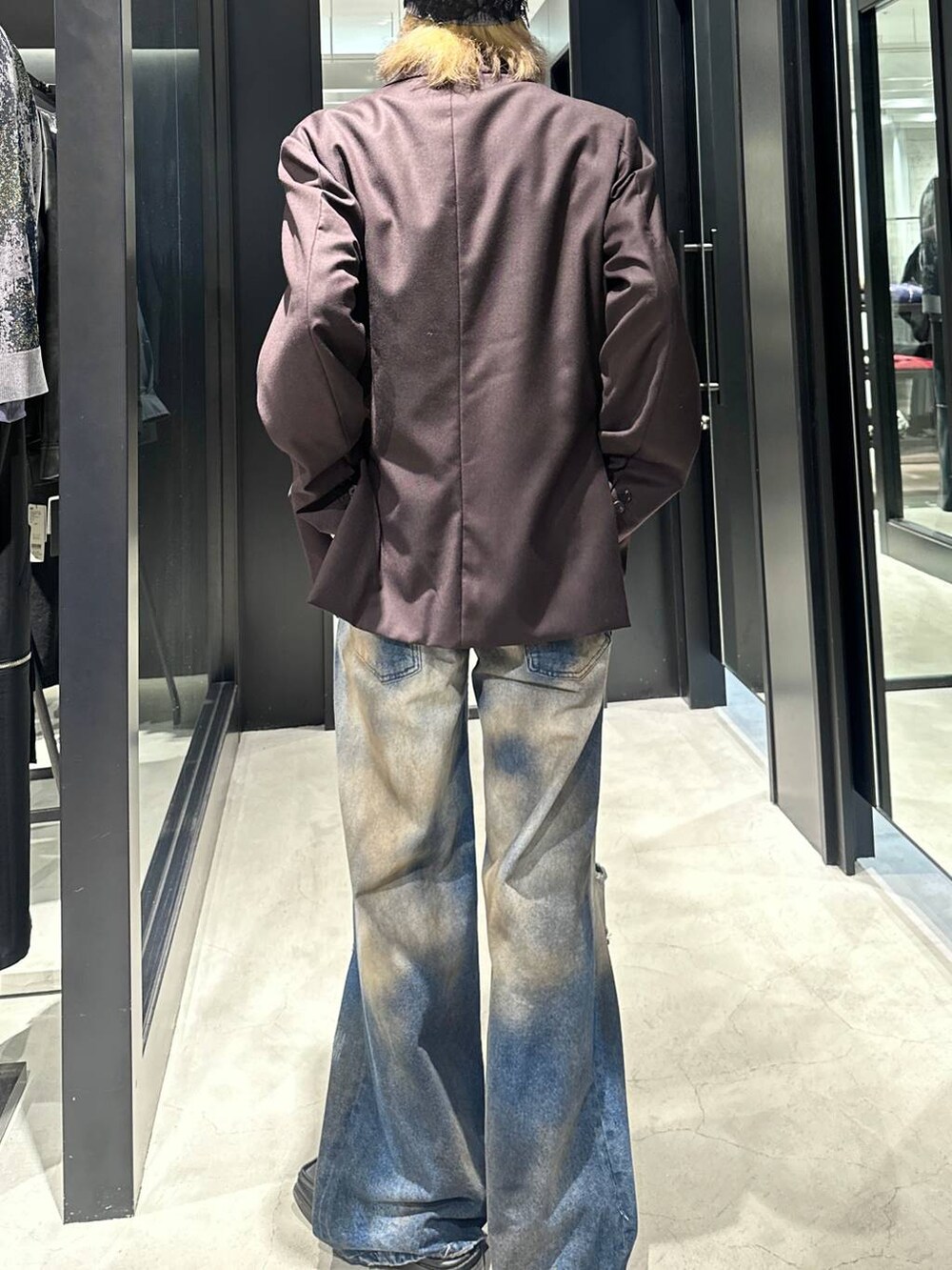 ブラウン系のテーラードジャケット、ブルー系のデニムパンツ、シルバー系のネックレスを着用したメンズの秋コーディネートの3枚目の写真