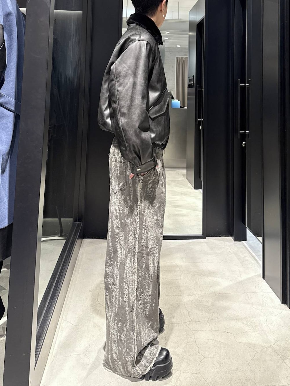 グレー系のブルゾン、ホワイト系のネックレスを着用したメンズの冬コーディネートの2枚目の写真