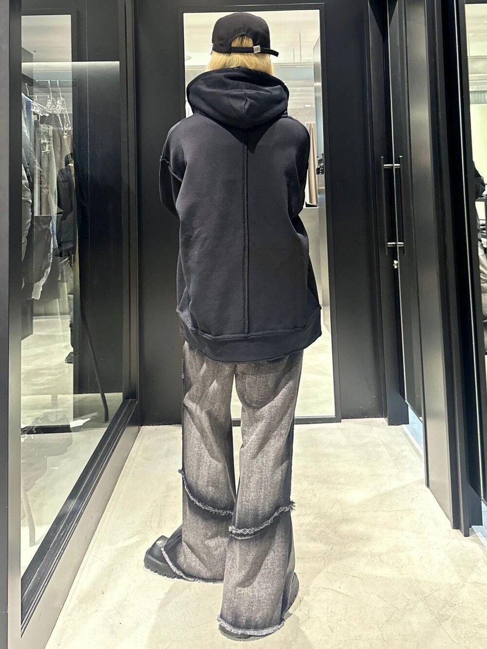 ブラック系のデニムパンツ、ブラック系のパーカー、ブラック系のキャップを着用したメンズの秋コーディネートの4枚目の写真