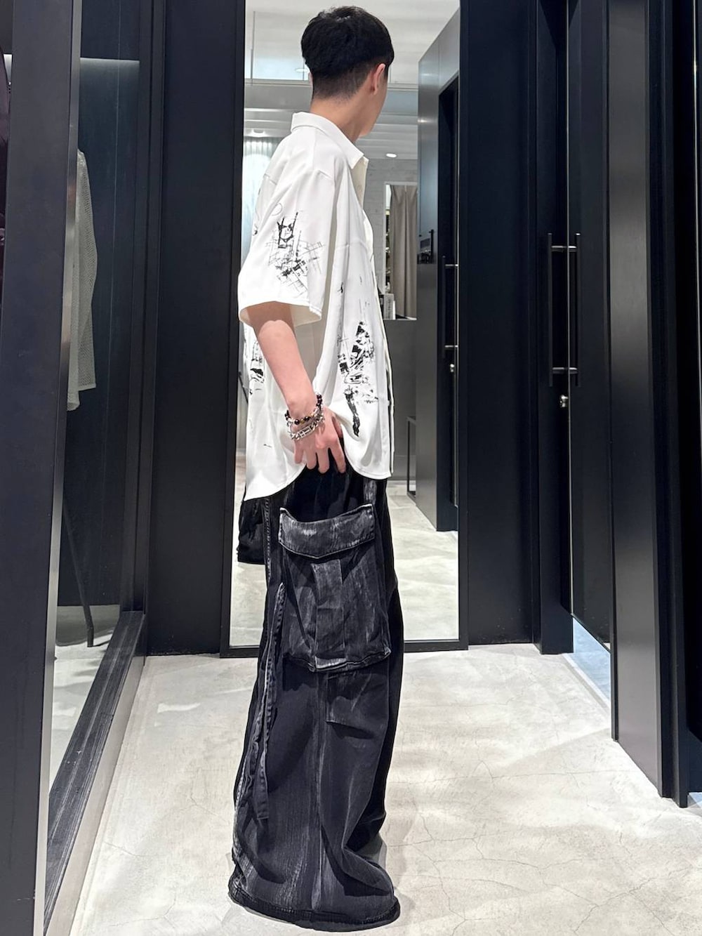ブラック系のカーゴパンツ、ブラック系のサンダル、ブラック系のタンクトップを着用したメンズの夏コーディネートの2枚目の写真
