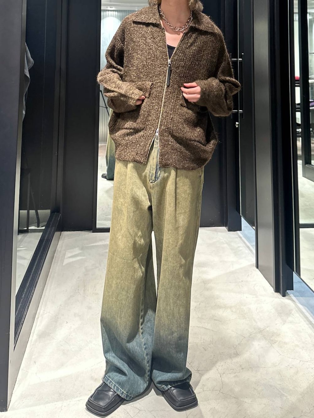 グリーン系のデニムパンツ、イエロー系のニット/セーター、シルバー系のネックレスを着用したメンズの秋コーディネートの2枚目の写真