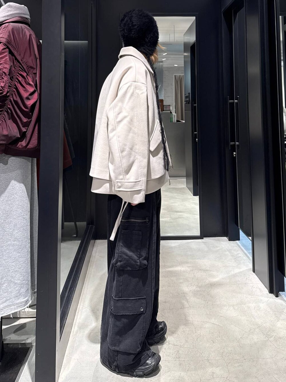 ホワイト系のブルゾン、ブラック系のカーゴパンツ、ブラック系のニットキャップ/ビーニーを着用したメンズの秋コーディネートの2枚目の写真