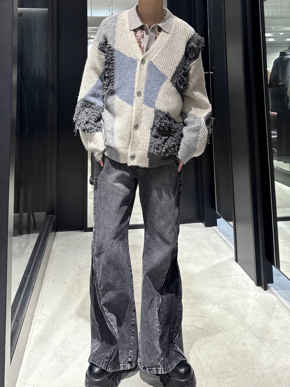ホワイト系のカーディガン/ボレロ、グレー系のニット/セーター、ブラック系のデニムパンツを着用したメンズの冬コーディネートの4枚目の写真