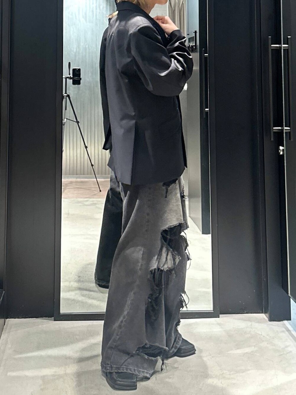 ブラック系のデニムパンツ、ブラック系のテーラードジャケット、シルバー系のネックレスを着用したメンズの秋コーディネートの3枚目の写真