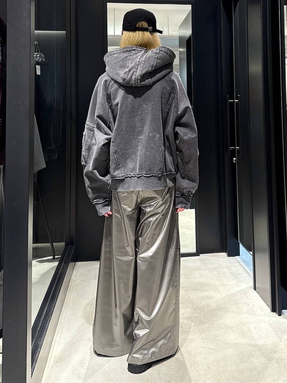 グレー系のパーカー、シルバー系のスラックス、ブラック系のその他シューズを着用したメンズの秋コーディネートの3枚目の写真