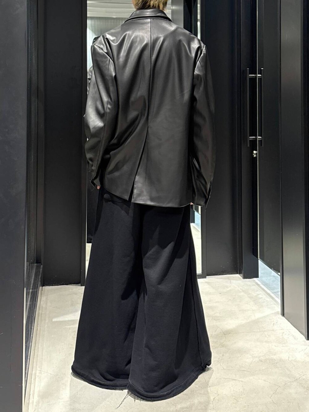 ブラック系のTシャツ/カットソー、ブラック系のスウェットパンツ、ブラック系のテーラードジャケットを着用したメンズの冬コーディネートの3枚目の写真