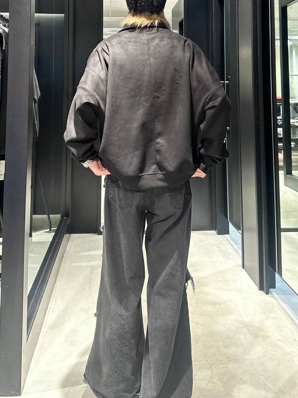 ブラック系のデニムパンツ、ブラック系のスウェット、シルバー系のネックレスを着用したメンズの秋コーディネートの4枚目の写真