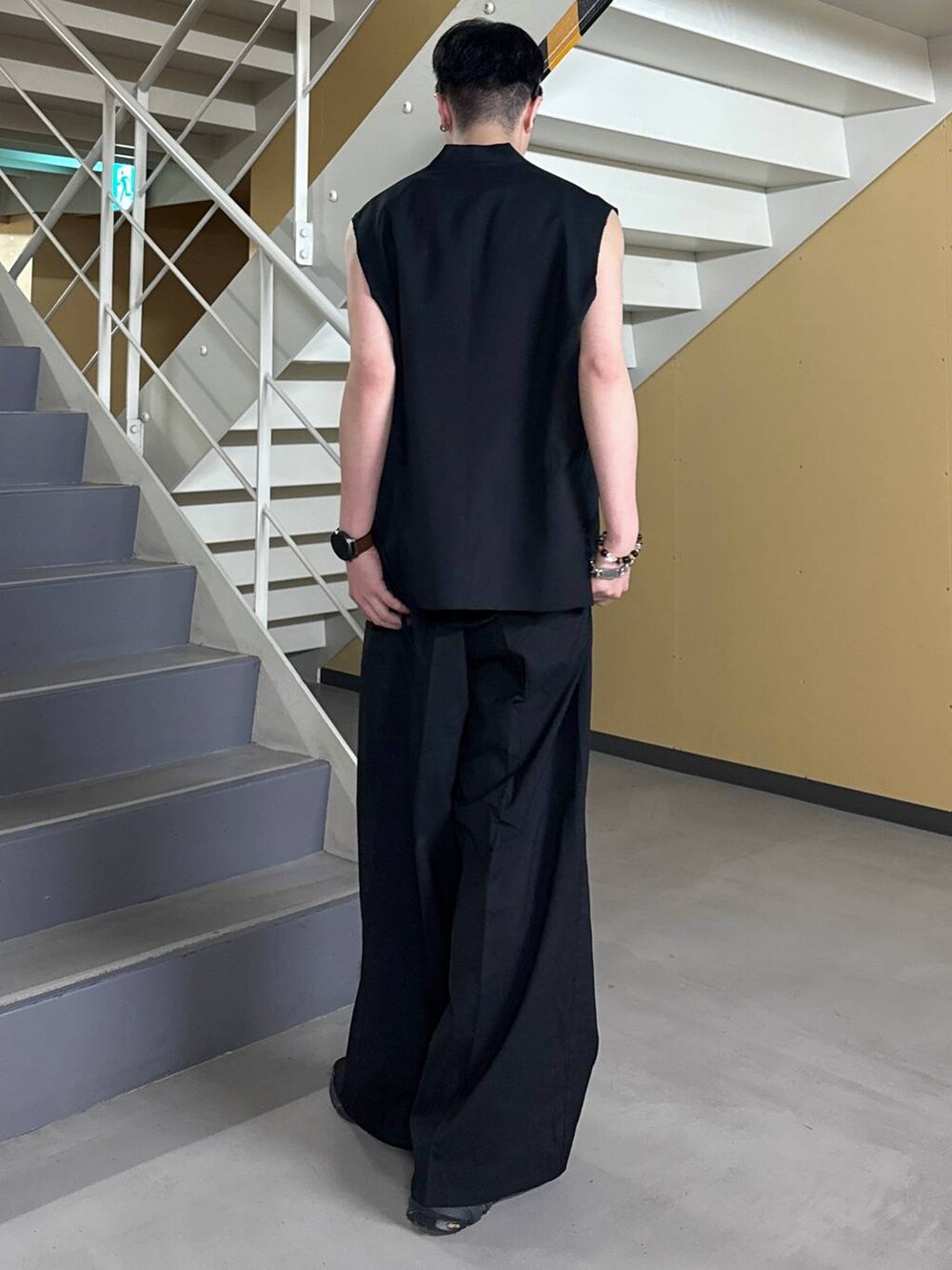 ブラック系のサンダル、ブラック系のタンクトップ、ブラック系のスラックスを着用したメンズの夏コーディネートの2枚目の写真