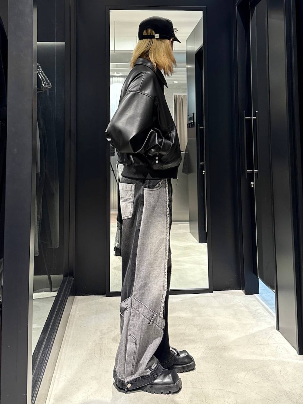ブラック系のデニムパンツ、ブラック系のブルゾン、ブラック系のキャップを着用したメンズの秋コーディネートの2枚目の写真