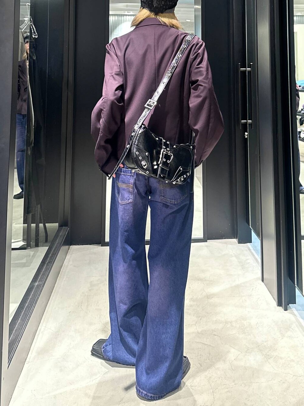 パープル系のデニムパンツ、レッド系のテーラードジャケット、ブラック系のショルダーバッグを着用したメンズの秋コーディネートの4枚目の写真