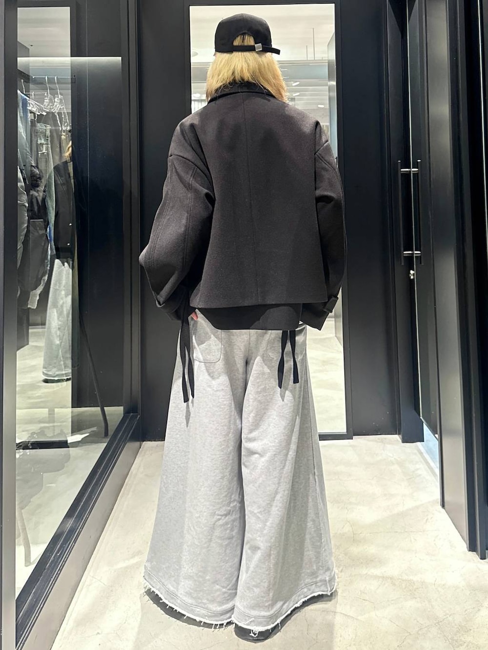 グレー系のスウェットパンツ、ブラック系のブルゾン、ブラック系のキャップを着用したメンズの秋コーディネートの3枚目の写真