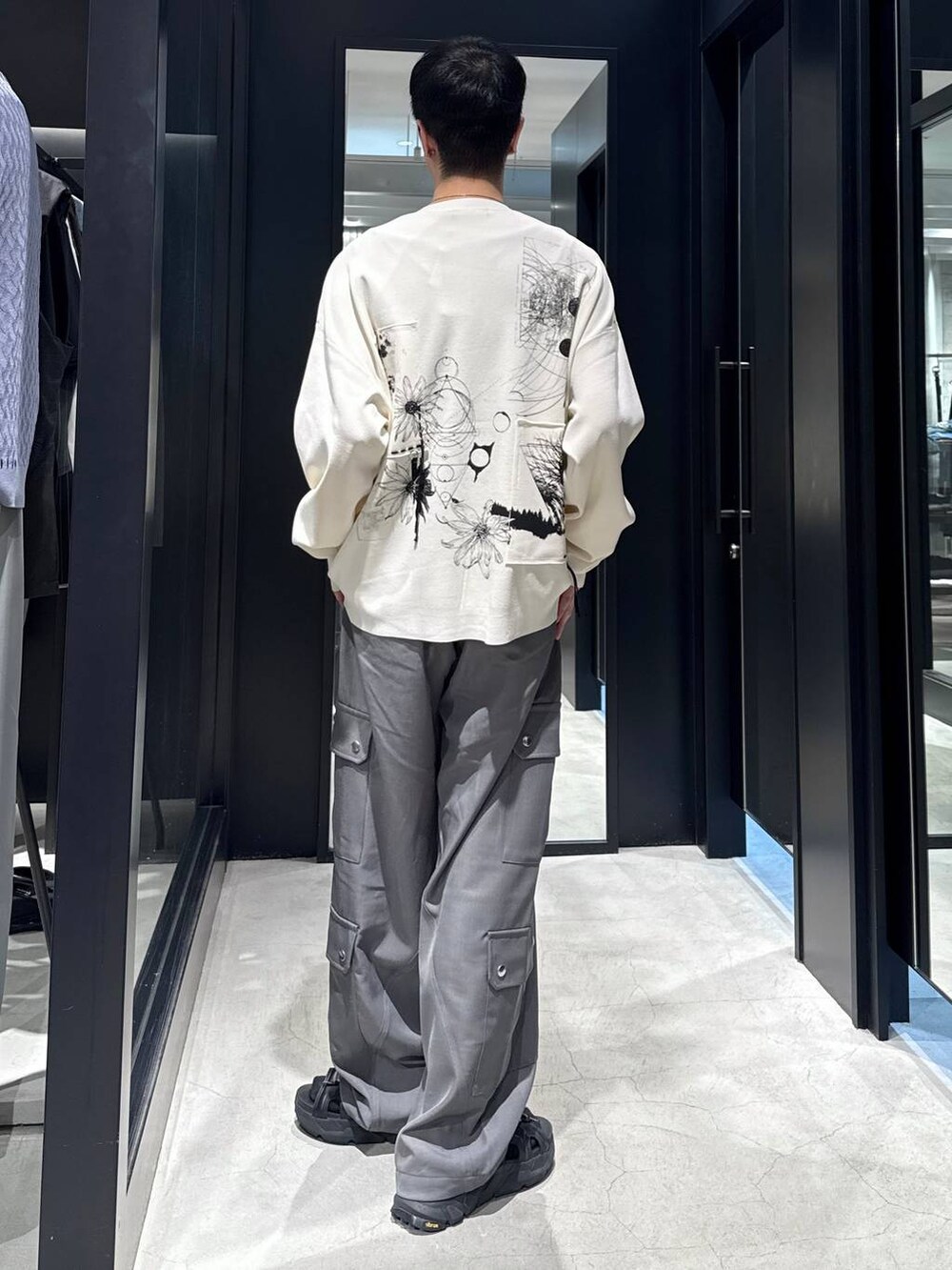 ブラック系のサンダル、ブラック系のタンクトップ、グレー系のカーゴパンツを着用したメンズの夏コーディネートの3枚目の写真