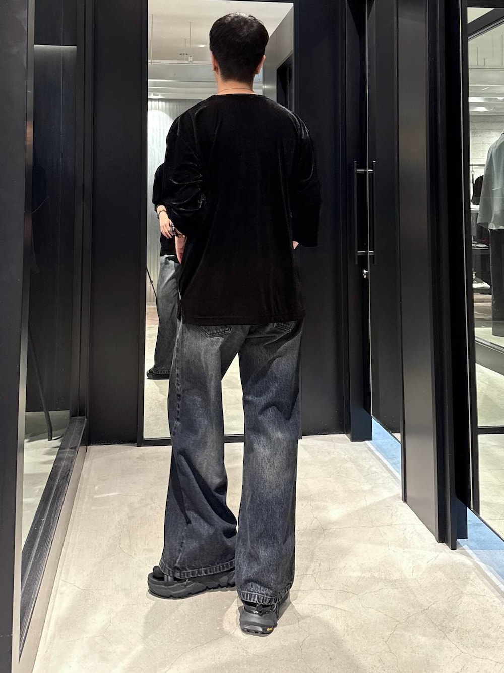 ブラック系のサンダル、ブルー系のデニムパンツ、ブラック系のTシャツ/カットソーを着用したメンズの夏コーディネートの3枚目の写真