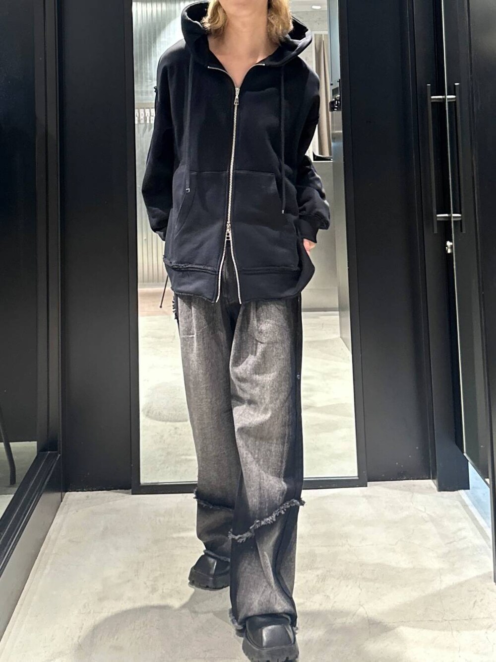 ブラック系のデニムパンツ、ブラック系のパーカー、ブラック系のキャップを着用したメンズの秋コーディネートの3枚目の写真