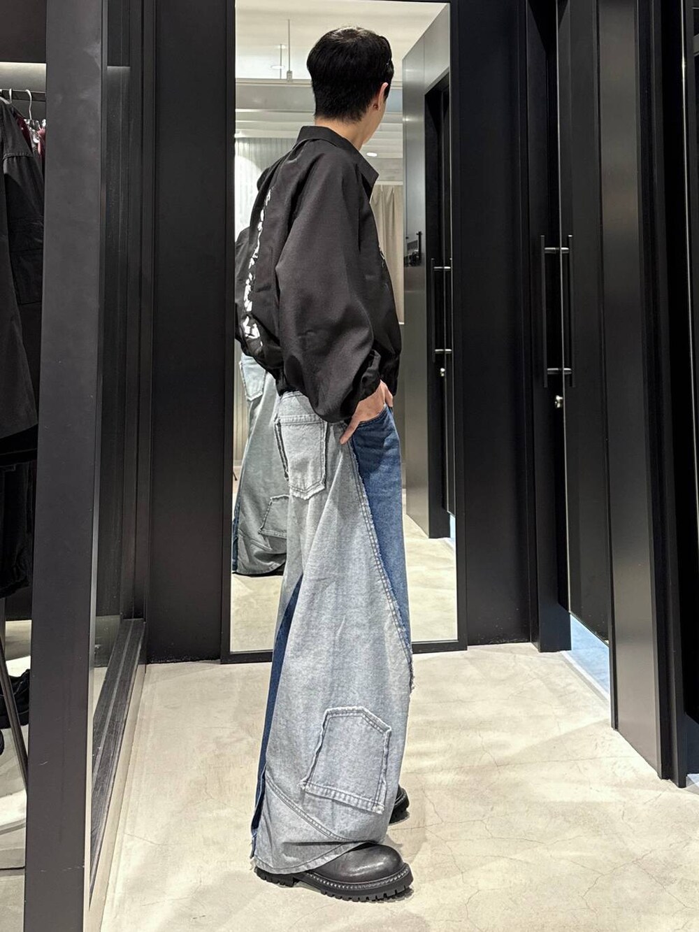 ホワイト系のTシャツ/カットソー、ブルー系のデニムパンツ、ブラック系のブーツを着用したメンズの秋コーディネートの2枚目の写真