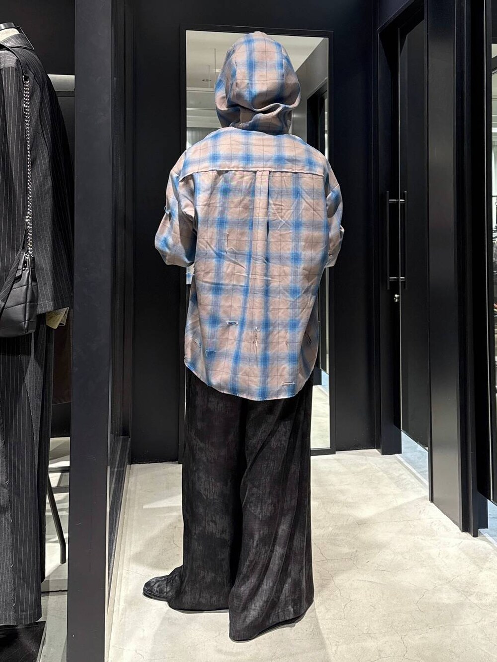 ブラック系のTシャツ/カットソー、グレー系のスラックス、ブラック系のキャップを着用したメンズの冬コーディネートの3枚目の写真