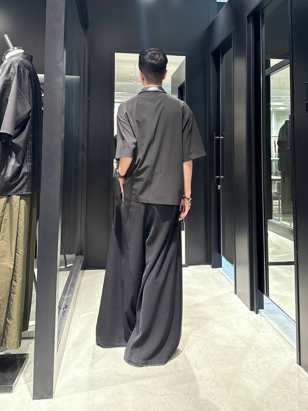 ブラック系のサンダル、ブラック系のスラックス、ブラック系のタンクトップを着用したメンズの夏コーディネートの2枚目の写真