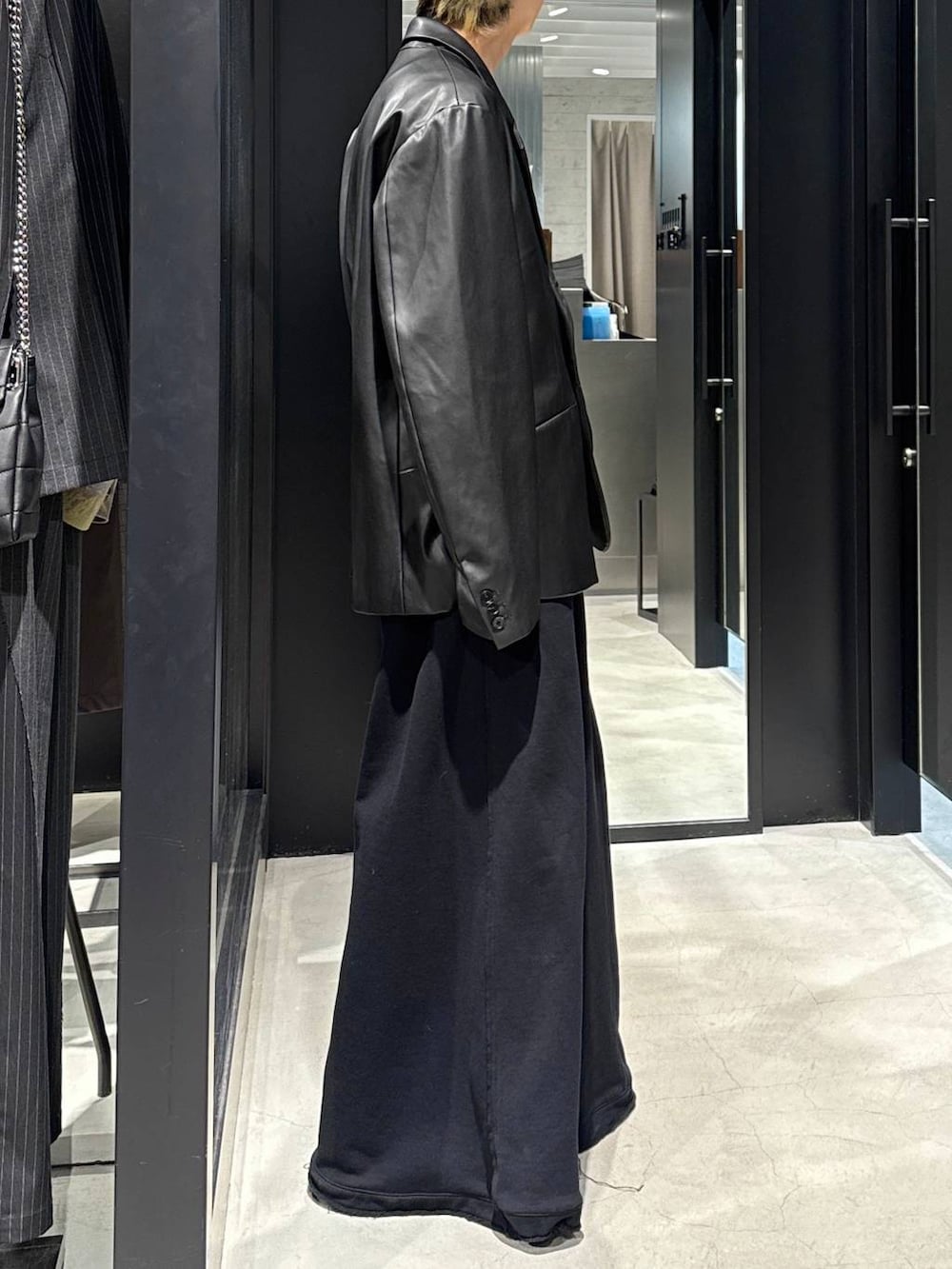 ブラック系のTシャツ/カットソー、ブラック系のスウェットパンツ、ブラック系のテーラードジャケットを着用したメンズの冬コーディネートの2枚目の写真