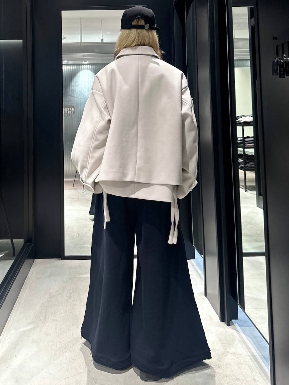 ブラック系のスウェットパンツ、ホワイト系のブルゾン、ブラック系のキャップを着用したメンズの秋コーディネートの3枚目の写真