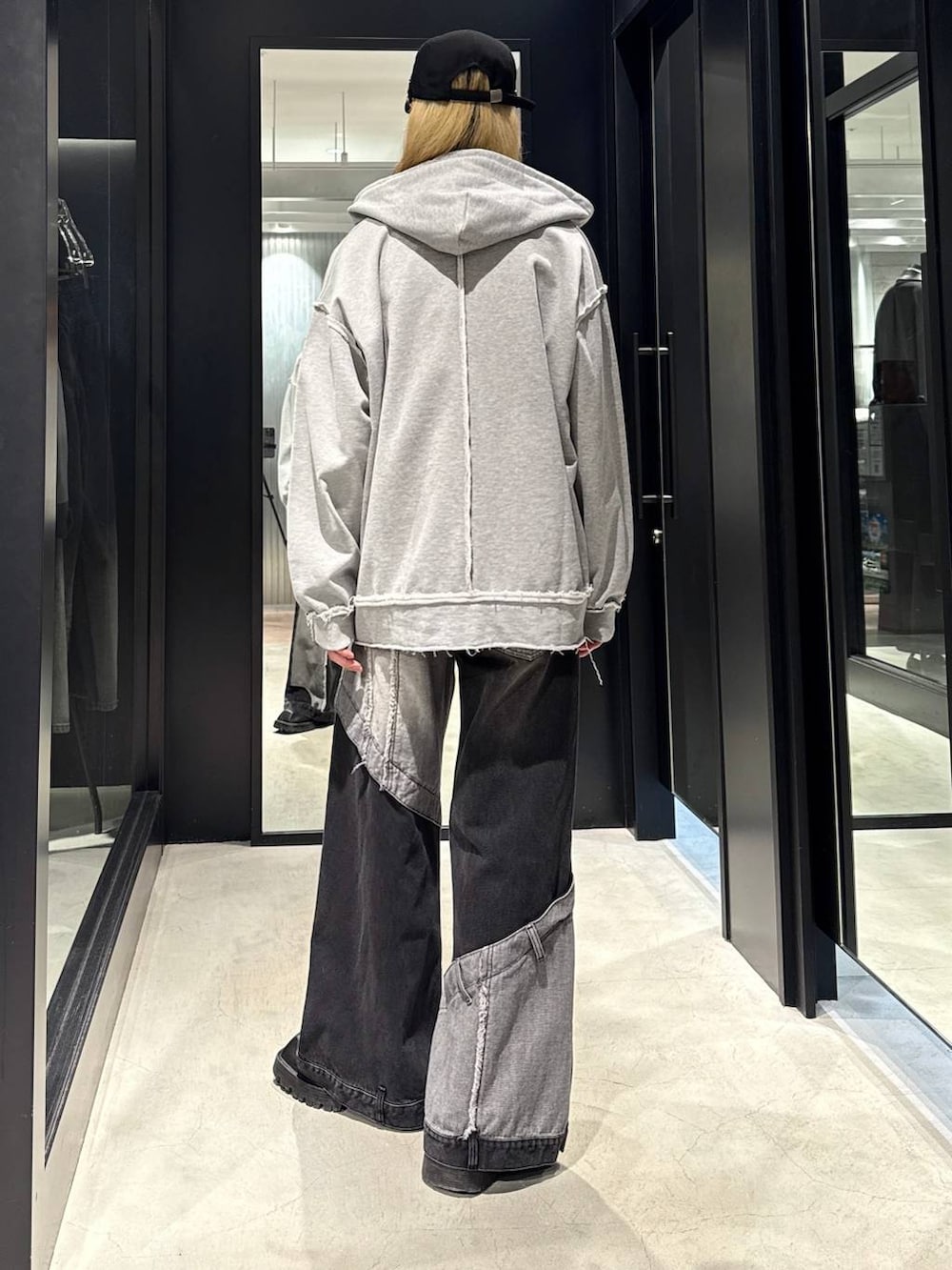 ブラック系のデニムパンツ、グレー系のパーカー、ブラック系のキャップを着用したメンズの秋コーディネートの3枚目の写真