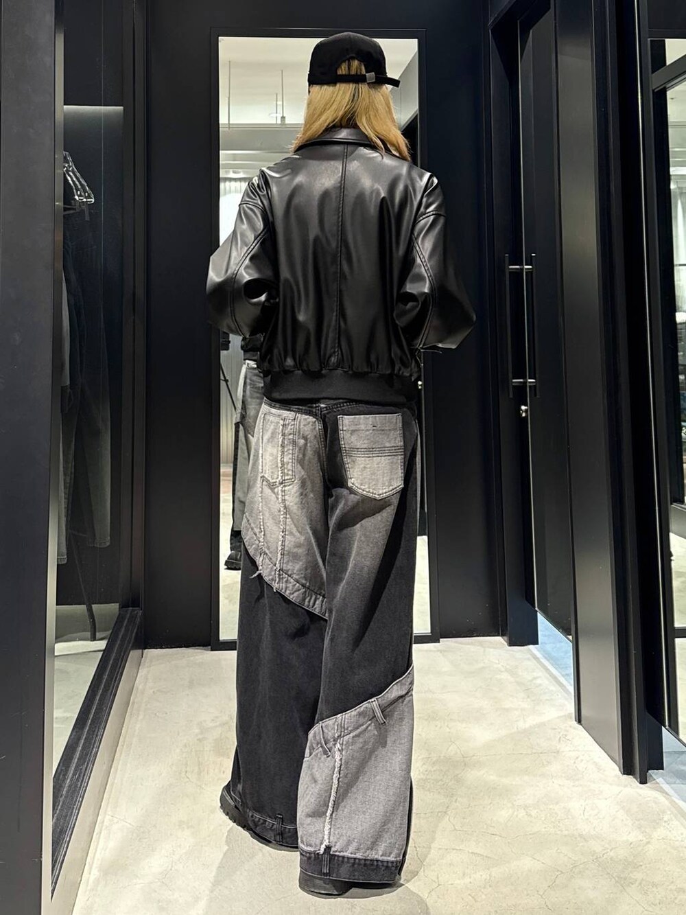 ブラック系のデニムパンツ、ブラック系のブルゾン、ブラック系のキャップを着用したメンズの秋コーディネートの3枚目の写真