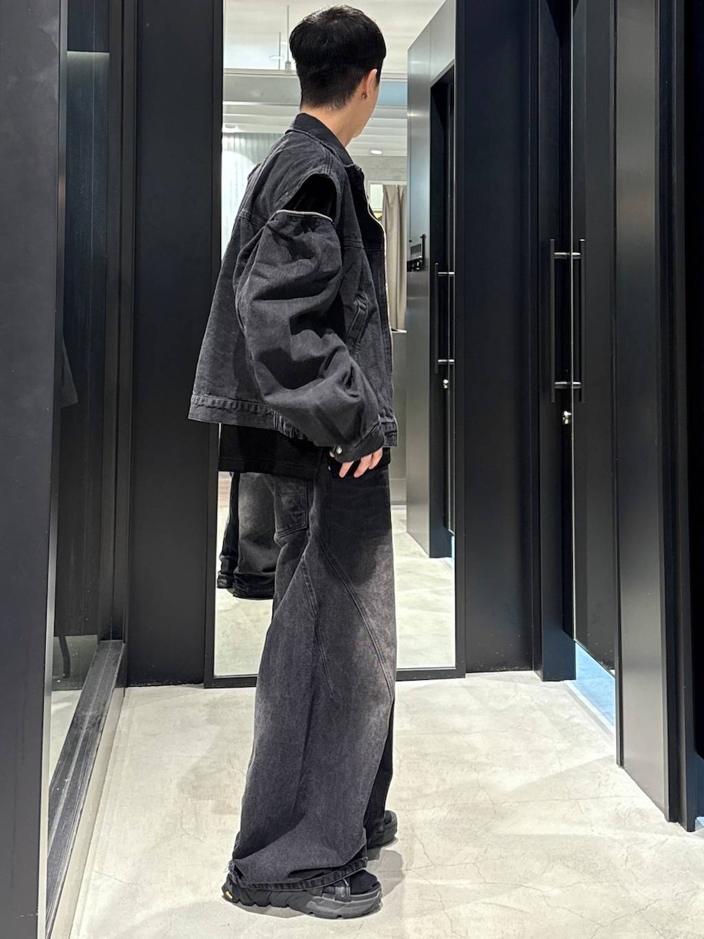 ブラック系のデニムパンツ、ブラック系のサンダル、ブラック系のブルゾンを着用したメンズの夏コーディネートの2枚目の写真