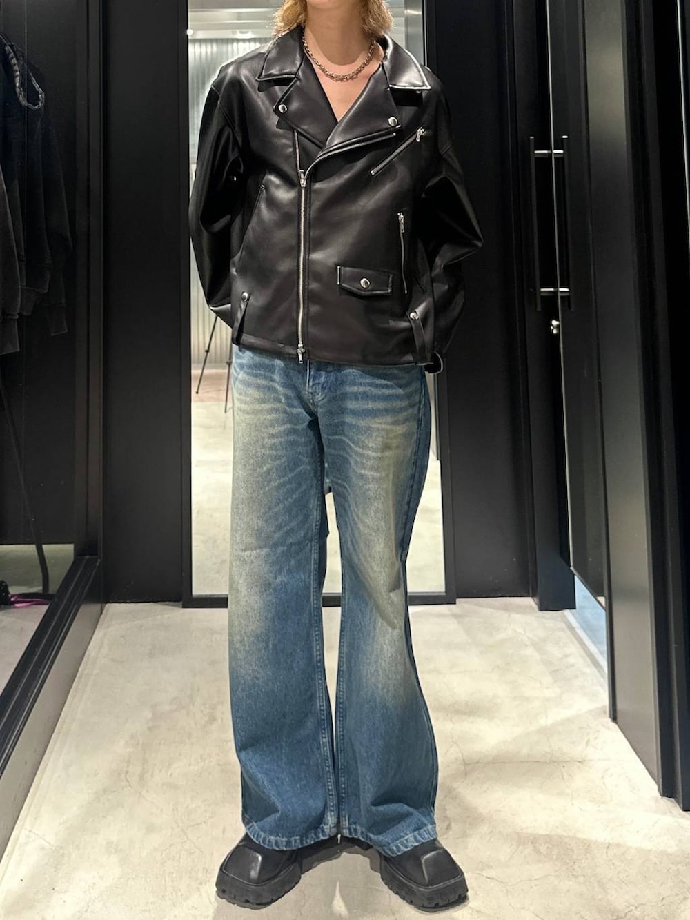 ブルー系のデニムパンツ、ブラック系のライダースジャケット、シルバー系のネックレスを着用したメンズの秋コーディネートの2枚目の写真