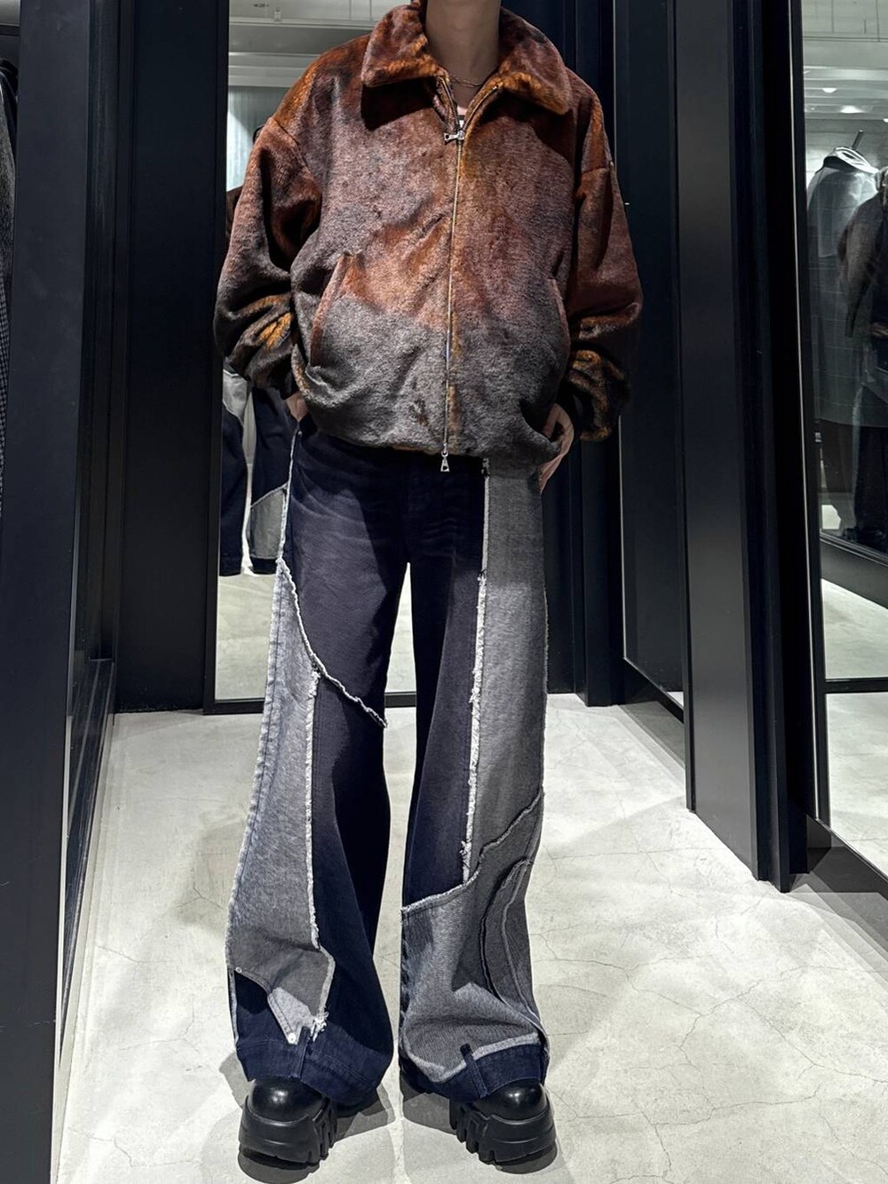 オレンジ系のブルゾン、ブルー系のデニムパンツを着用したメンズの秋コーディネートの4枚目の写真