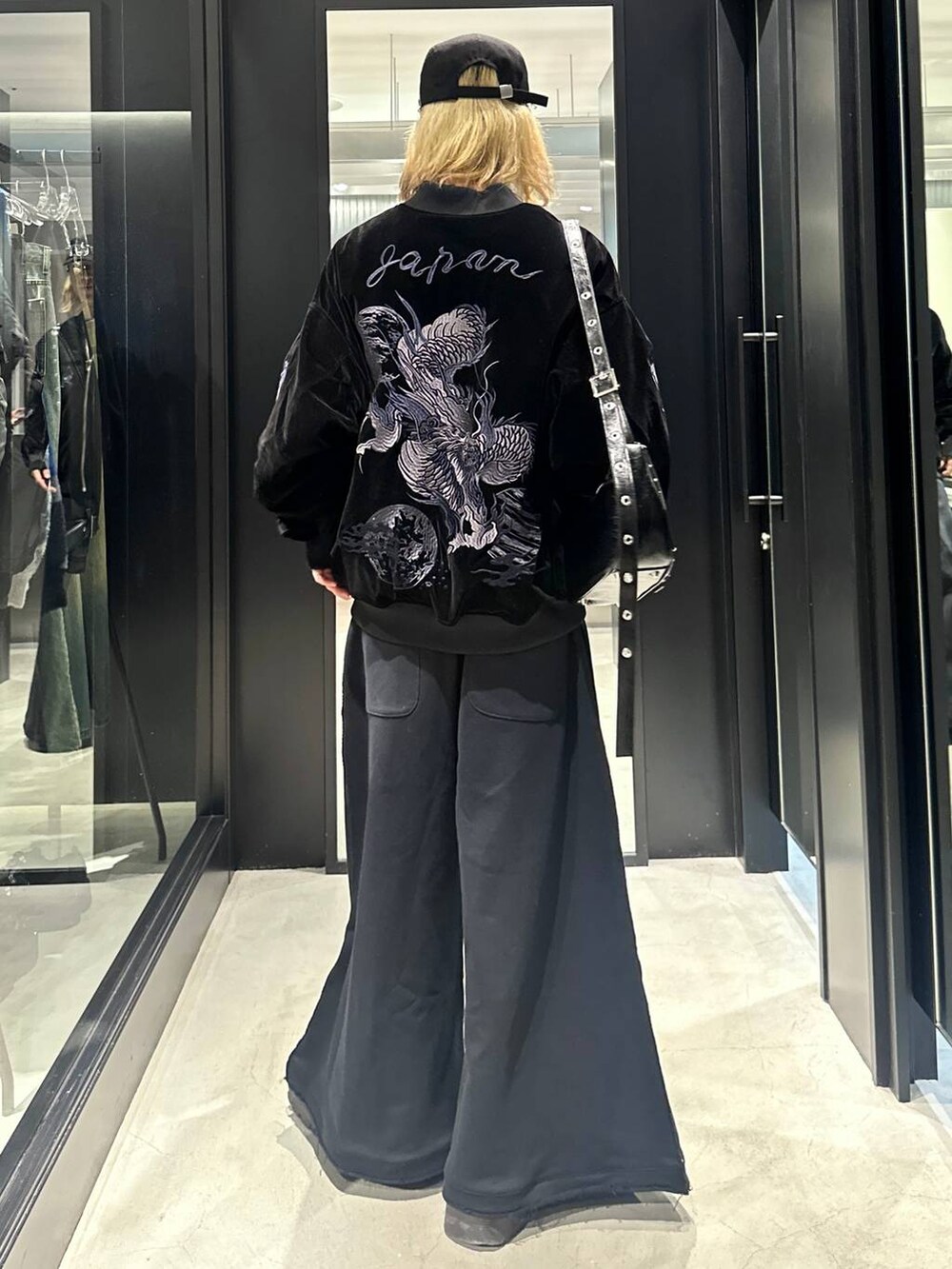 ブラック系のスウェットパンツ、ブラック系のショルダーバッグ、ブラック系のブルゾンを着用したメンズの秋コーディネートの2枚目の写真