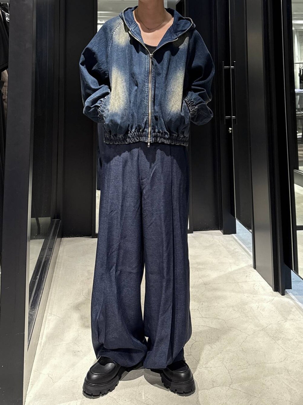 ブルー系のスラックス、ブラック系のTシャツ/カットソー、ブラック系のドレスシューズを着用したメンズの秋コーディネートの4枚目の写真