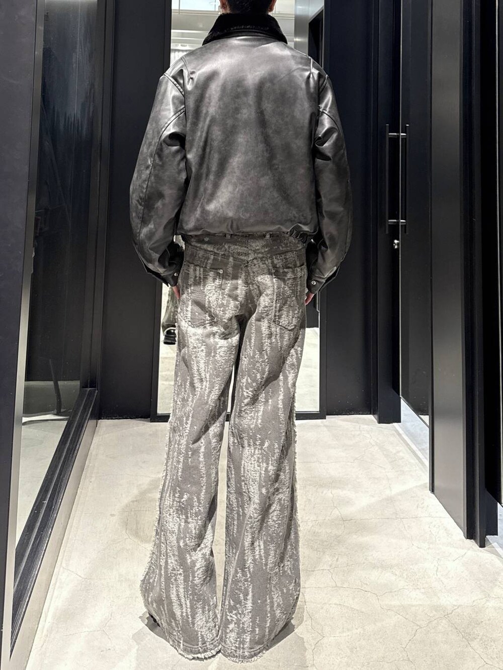 グレー系のブルゾン、ホワイト系のネックレスを着用したメンズの冬コーディネートの3枚目の写真