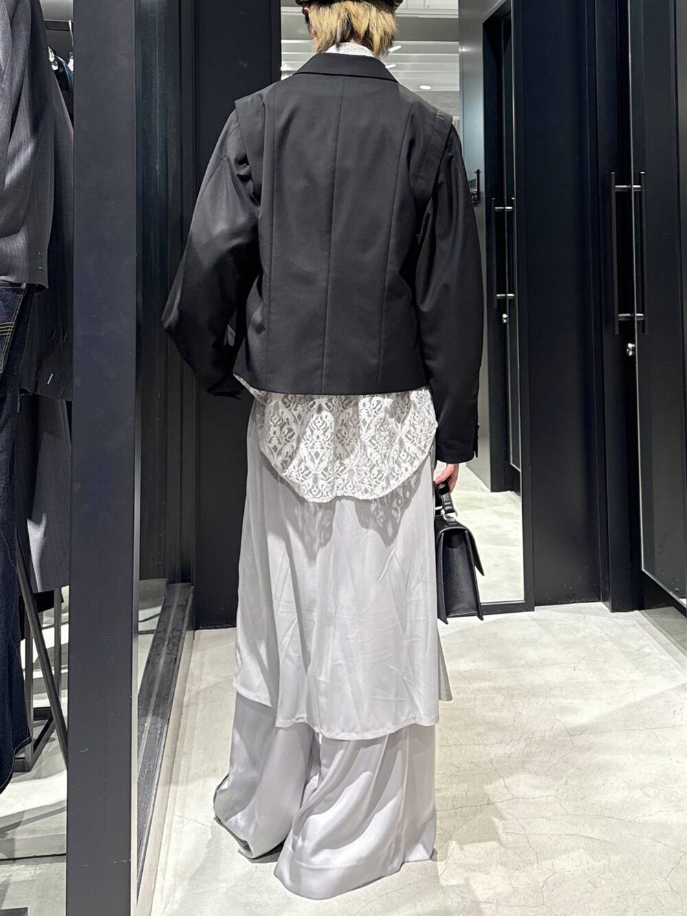 ブラック系のハンドバッグ、グレー系のTシャツ/カットソー、ブラック系のテーラードジャケットを着用したメンズの春コーディネートの3枚目の写真