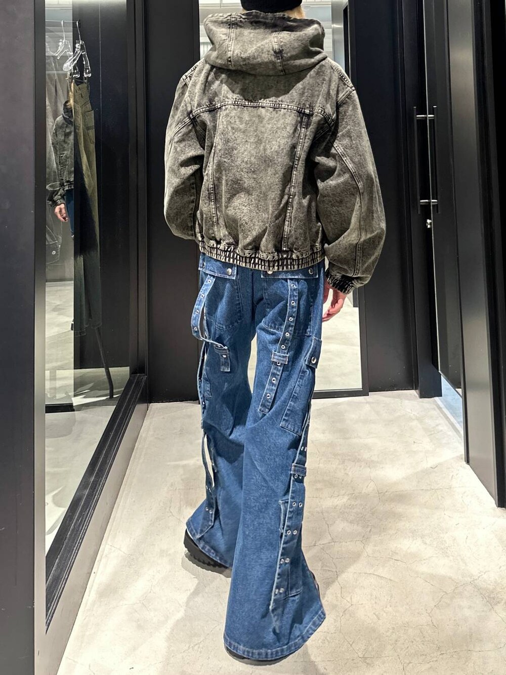 グリーン系のブルゾン、ブラック系のその他シューズ、ブルー系のデニムパンツを着用したメンズの秋コーディネートの3枚目の写真