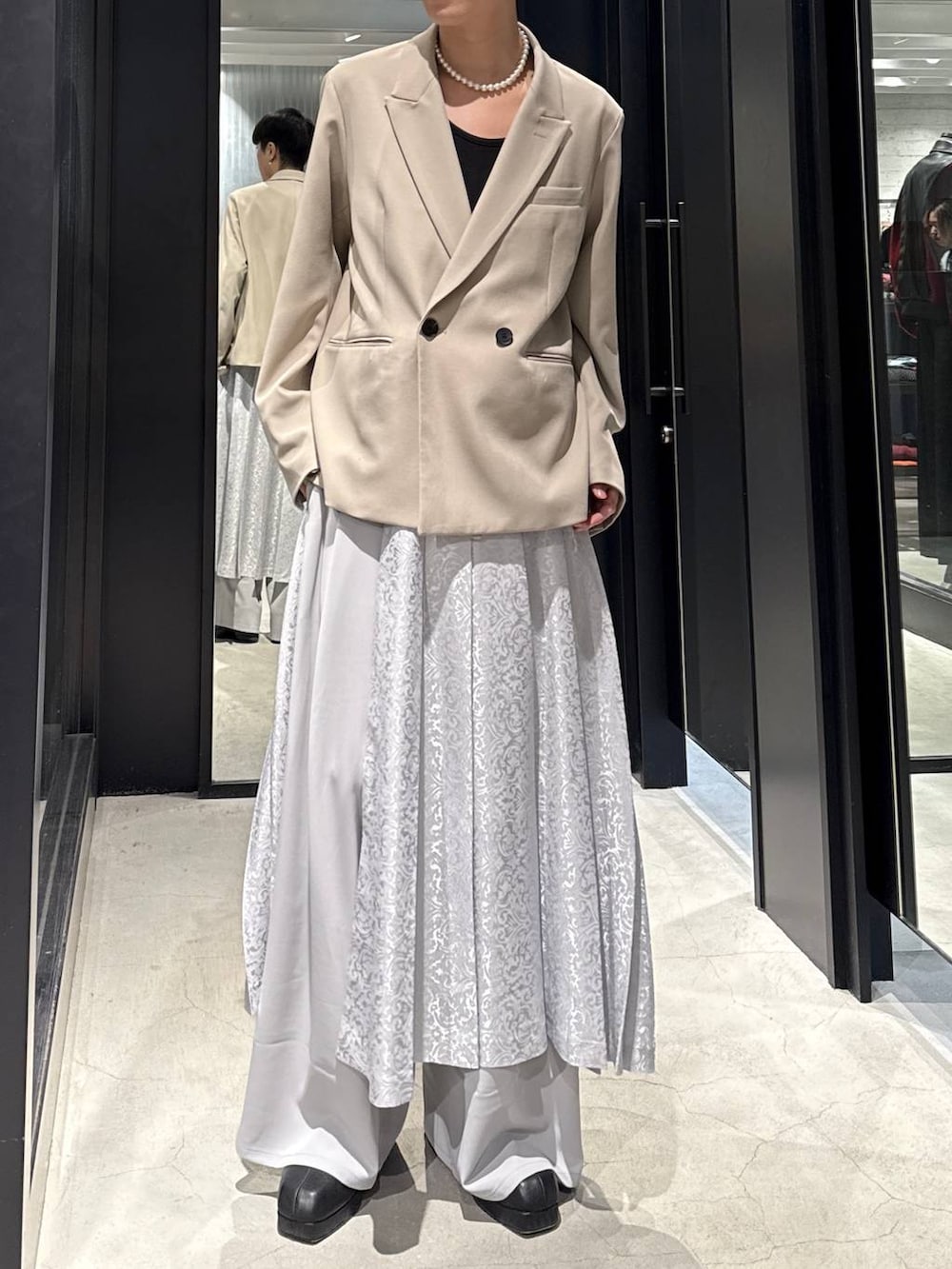 ブラック系のブーツ、ベージュ系のテーラードジャケット、グレー系のその他パンツを着用したメンズの冬コーディネートの4枚目の写真