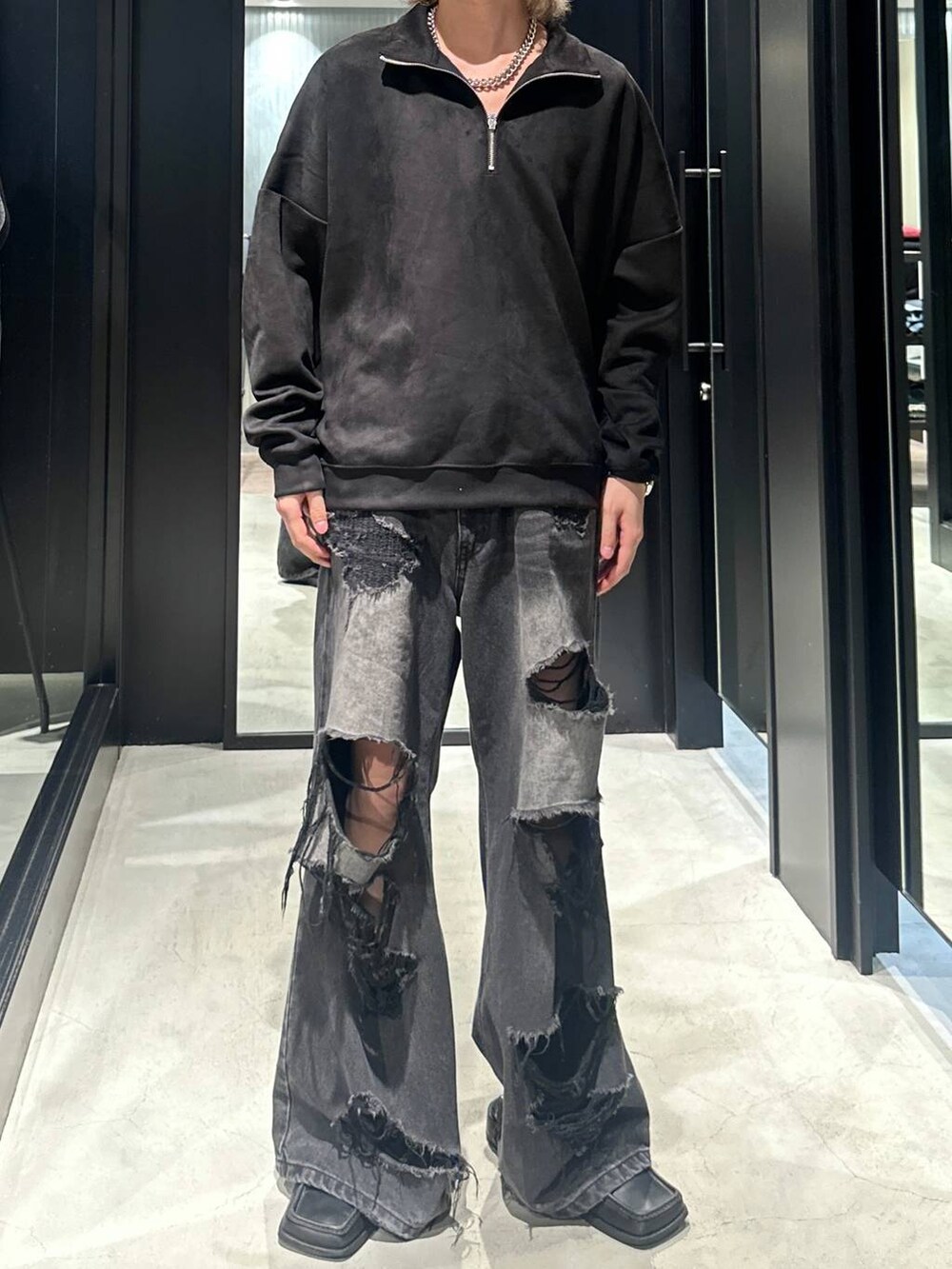 ブラック系のデニムパンツ、ブラック系のスウェット、シルバー系のネックレスを着用したメンズの秋コーディネートの2枚目の写真