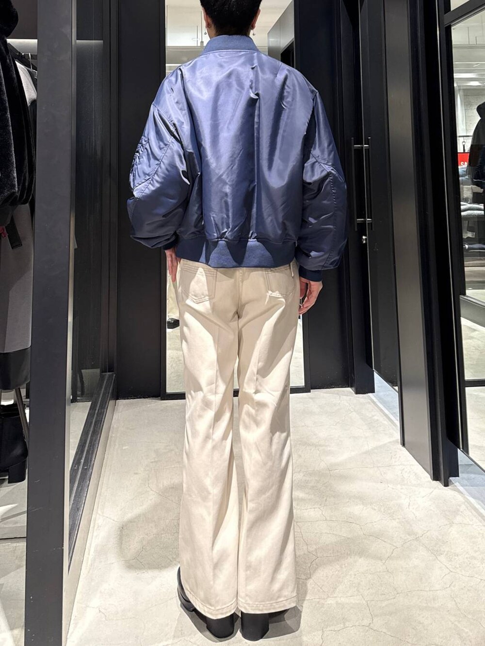 ブラック系のブーツ、ブルー系のMA-1、ホワイト系のデニムパンツを着用したメンズの冬コーディネートの2枚目の写真