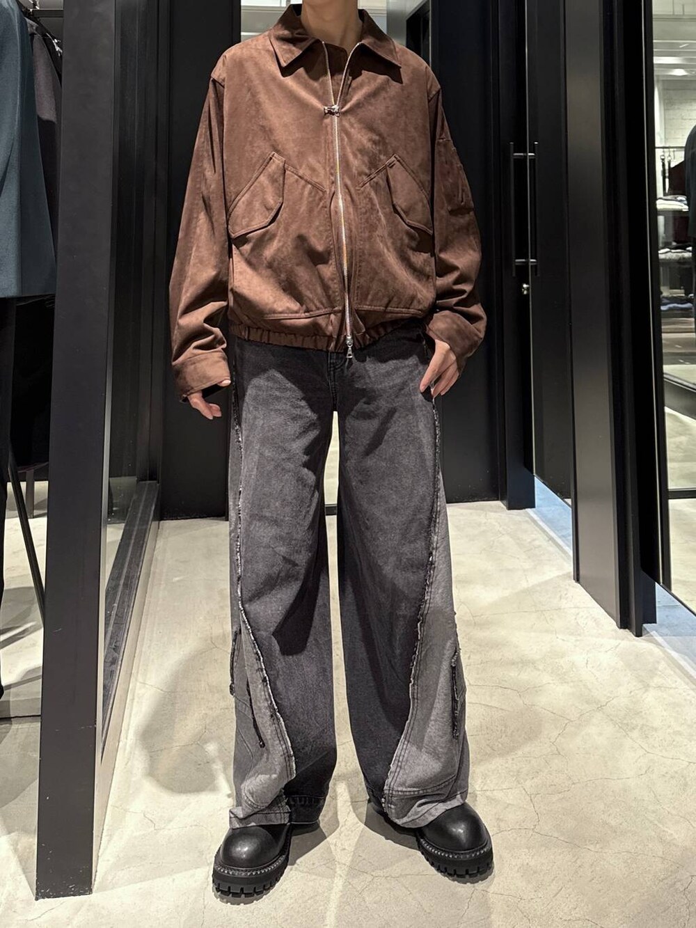 ブラック系のデニムパンツ、ブラウン系のブルゾン、ブラック系のTシャツ/カットソーを着用したメンズの秋コーディネートの4枚目の写真