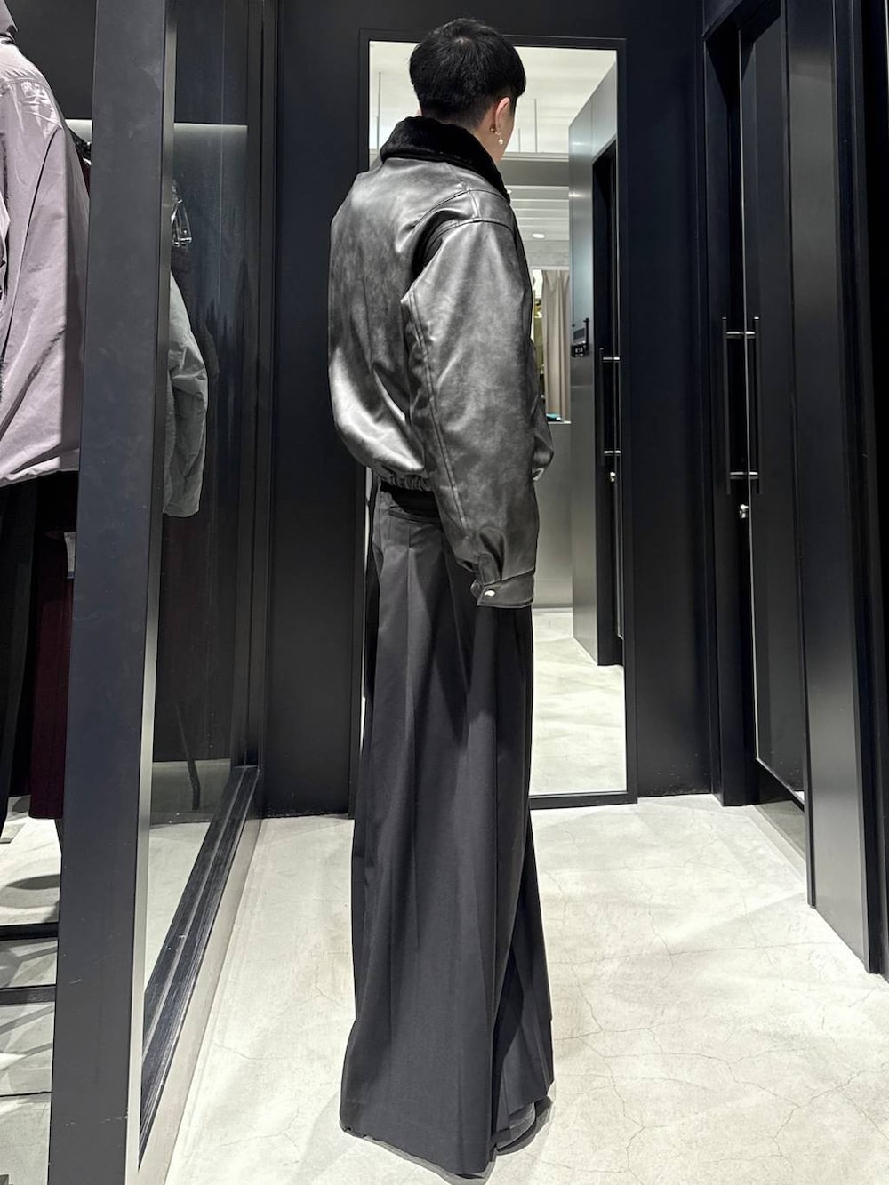 グレー系のブルゾン、ブラック系のスラックスを着用したメンズの冬コーディネートの2枚目の写真